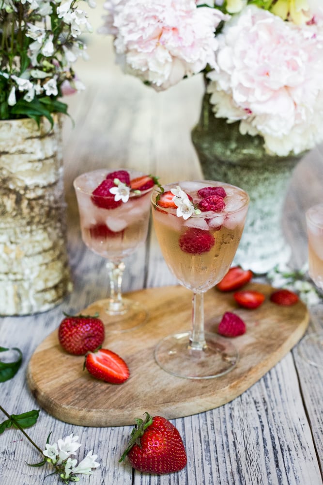 A glass of rhubarb rosé sangria surrounded by flowers