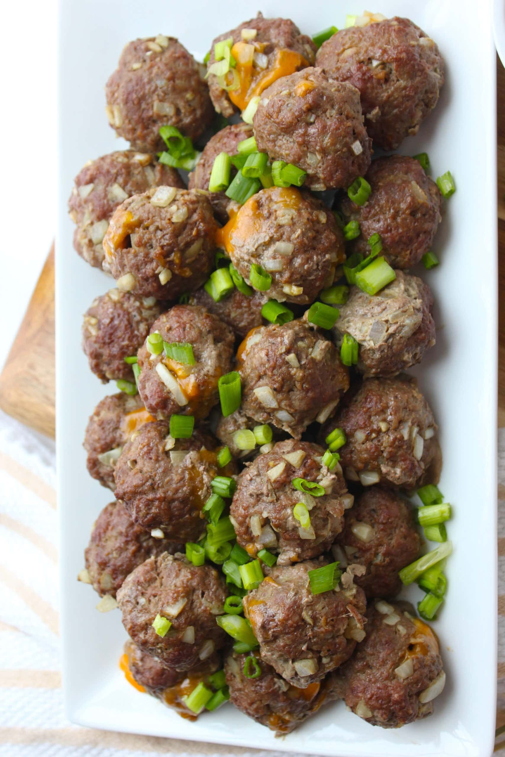 A plate of juicy Lucy meatballs topped with green onions