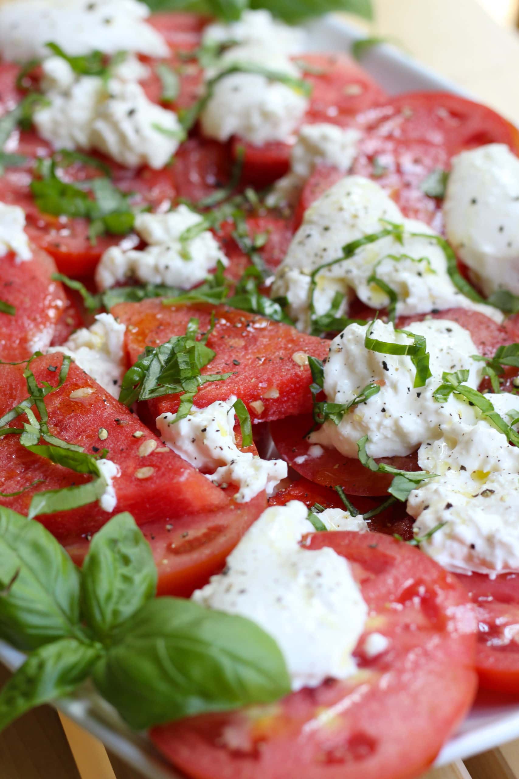 Watermelon and mozzarella on a platter topped with basil