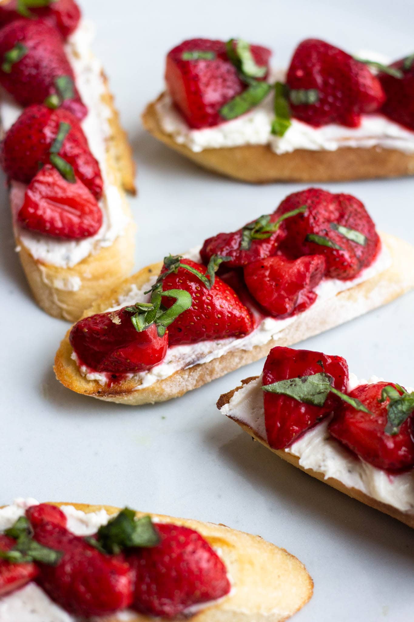 A plate filled with strawberry and rondelé crostini