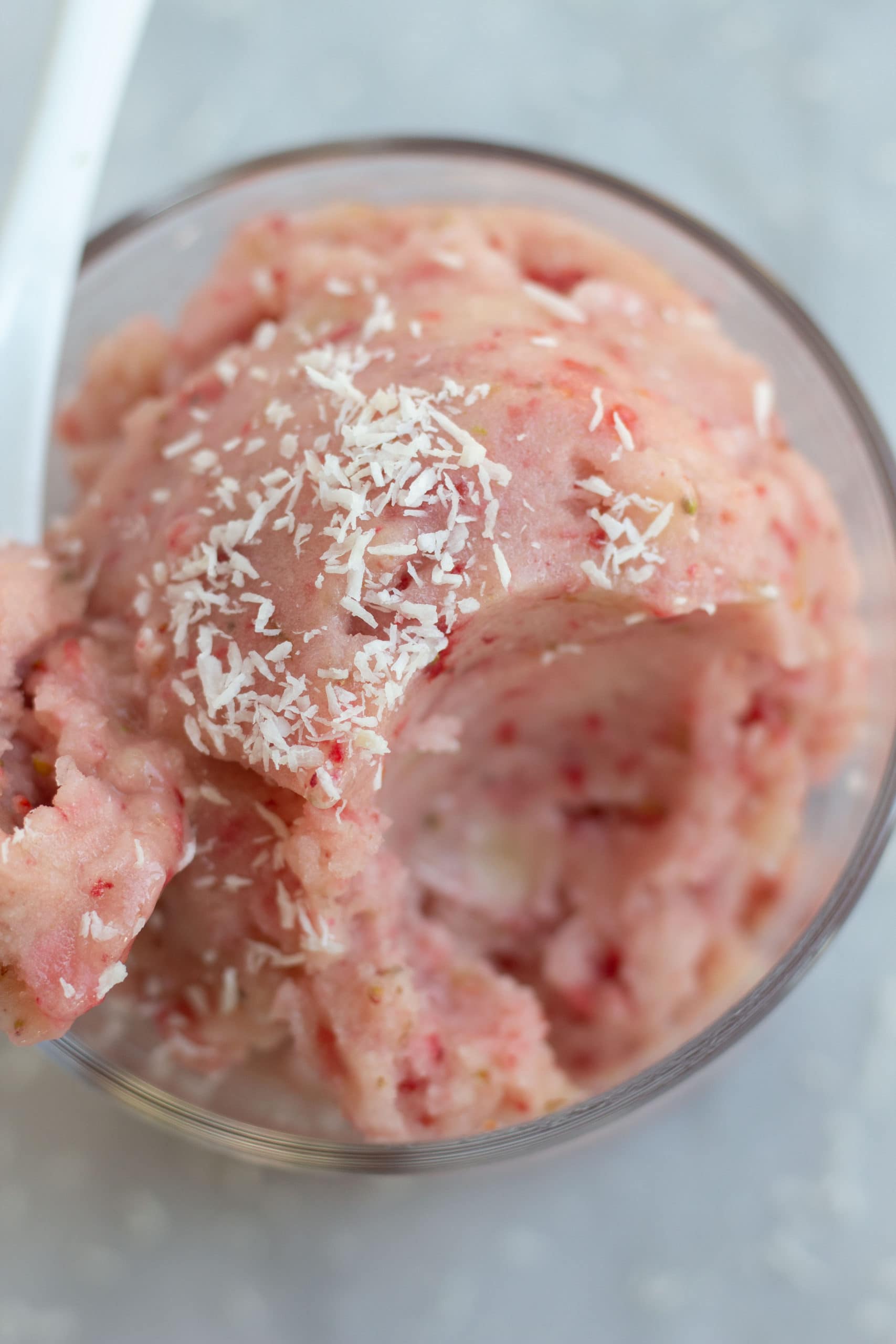 A bowl of strawberry nice cream topped with coconut