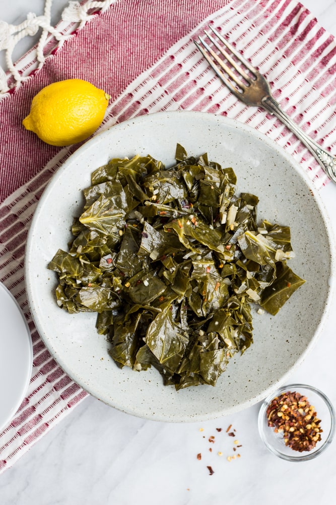 Brasied Collard Greens in a bowl with lemon and red pepper flakes