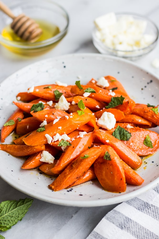 A plate of honey glazed carrots with feta and mint