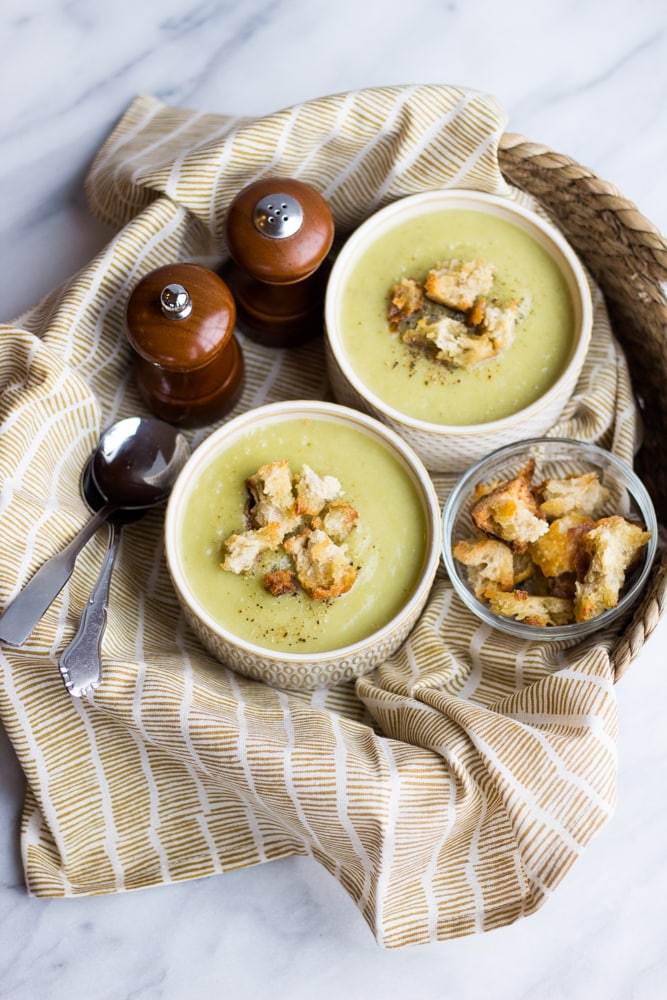 Two bowls of potato leek soup with sourdough croutons