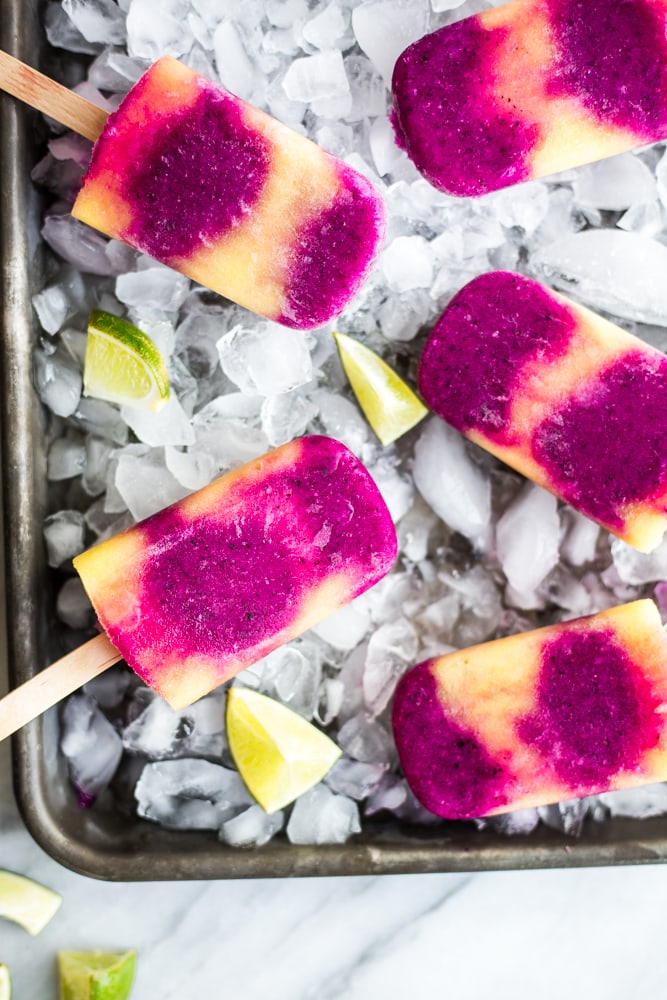 A platter covered in ice and topped with Pineapple and Dragonfruit Paletas