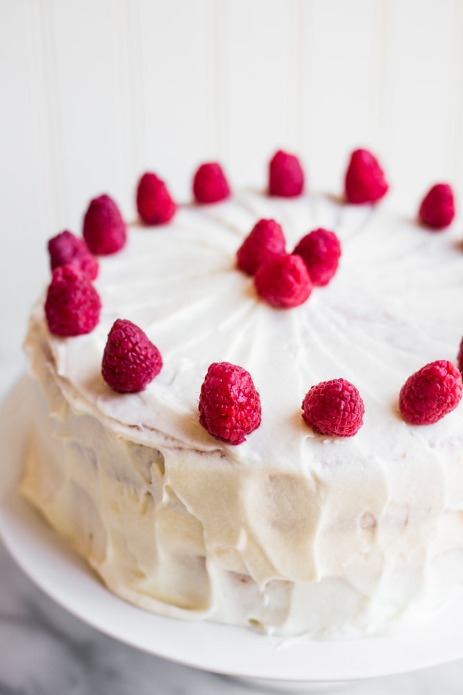 A white cake topped with raspberries