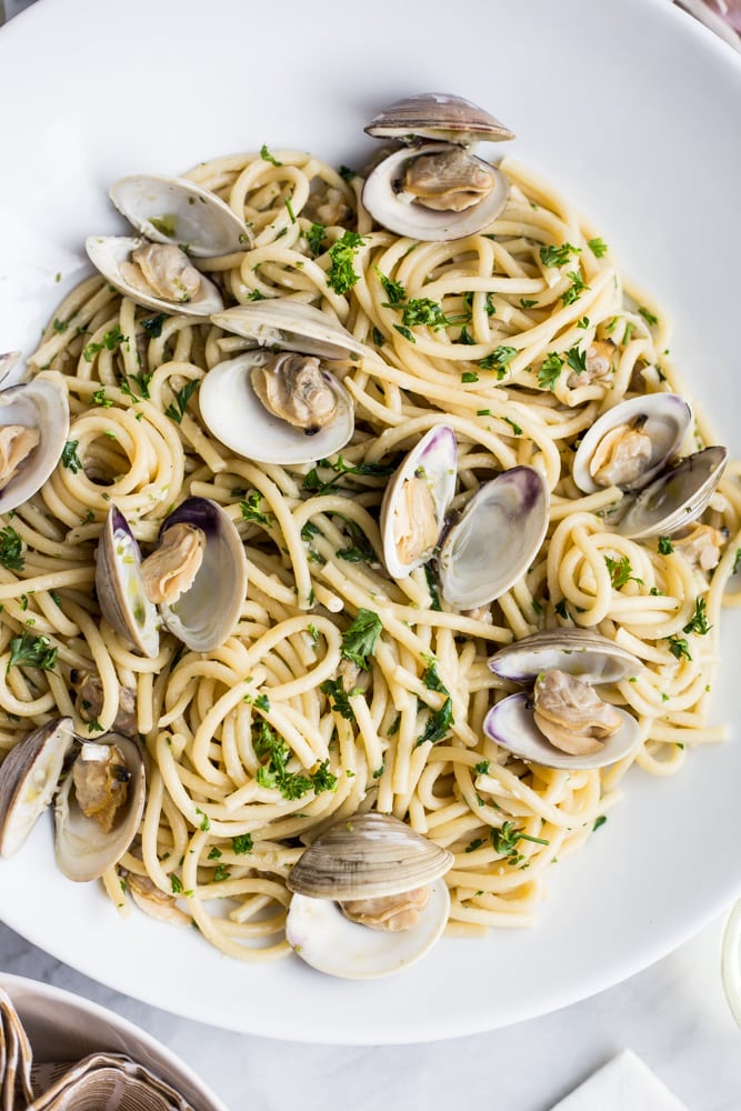 A plate of pasta with clams and parsley