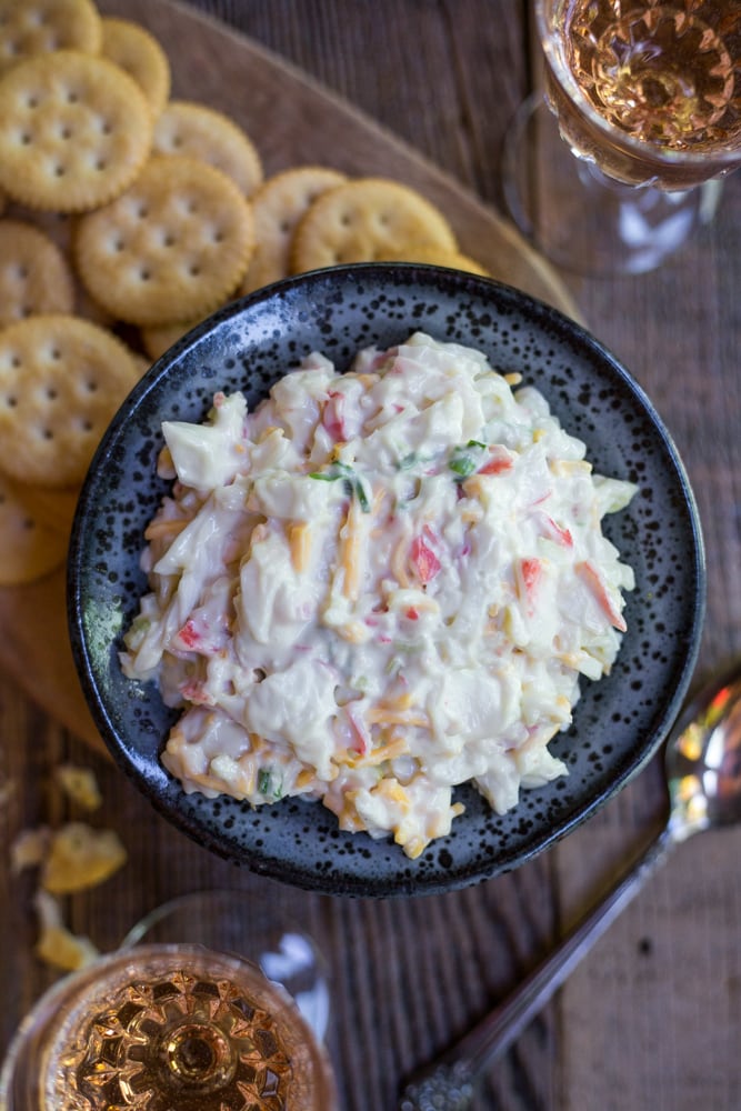 A bowl of crab dip surrounded by crackers