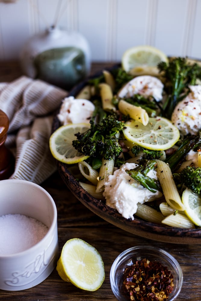 A plate of pasta with roasted broccolini, lemon, and burrata