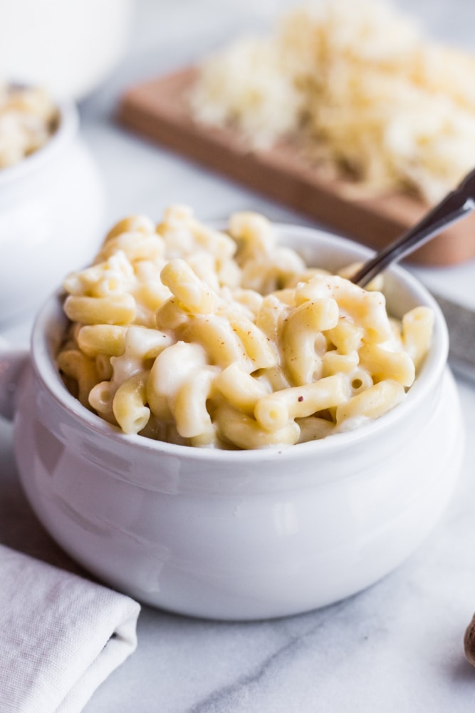 A bowl of creamy macaroni and cheese with a spoon