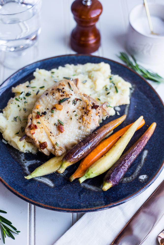 A blue plate with beer braised chicken, mashed potatoes, and roasted carrots
