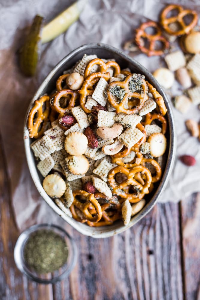 A bowl of snack mix made of Chex cereal, pretzels, crackers, and mixed nuts