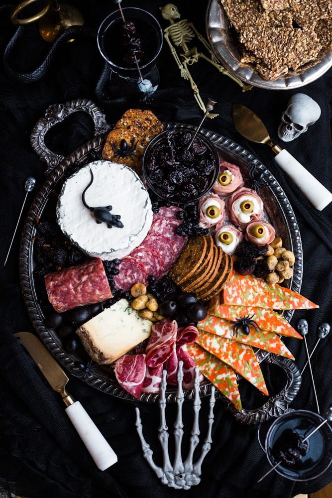 A charcuterie platter with eerie Halloween props