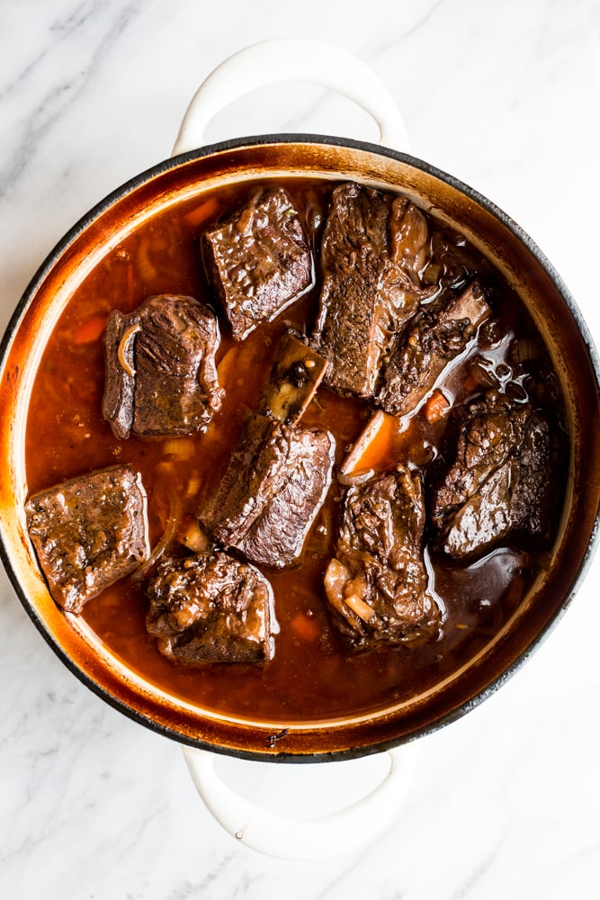 A dutch oven filled with red wine braised short ribs