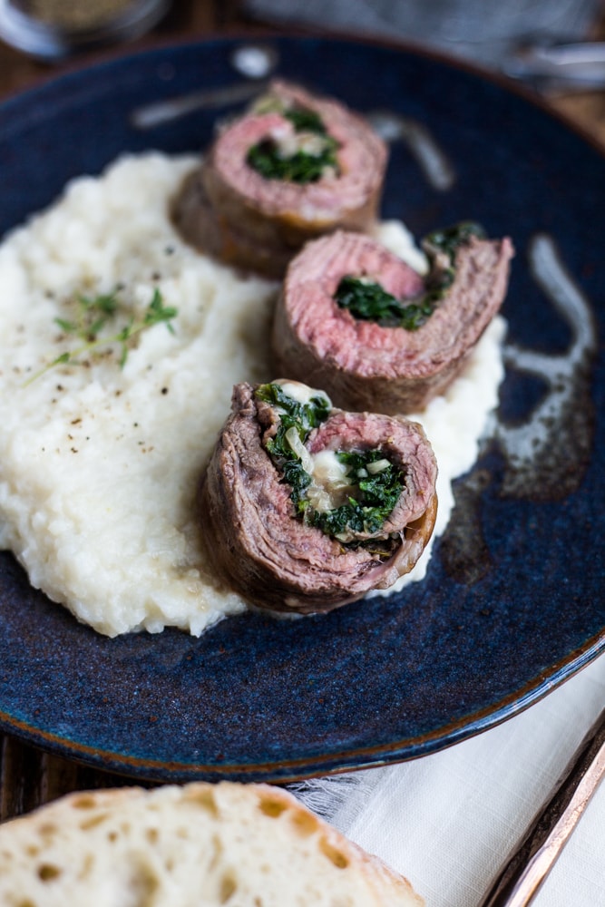 A plate of steak roll ups over mashed cauliflower