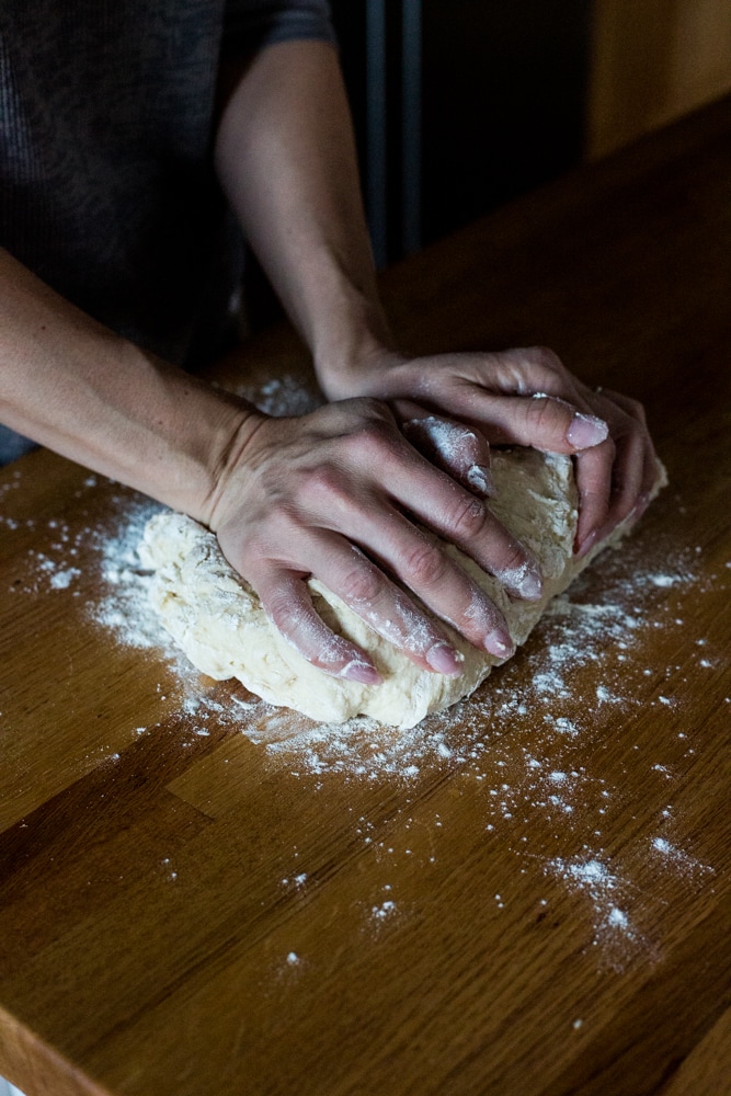 Hands kneading dough on a countertop
