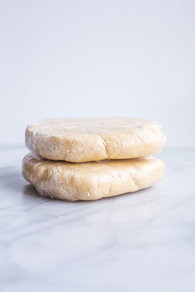 Two pie crust disks wrapped in plastic