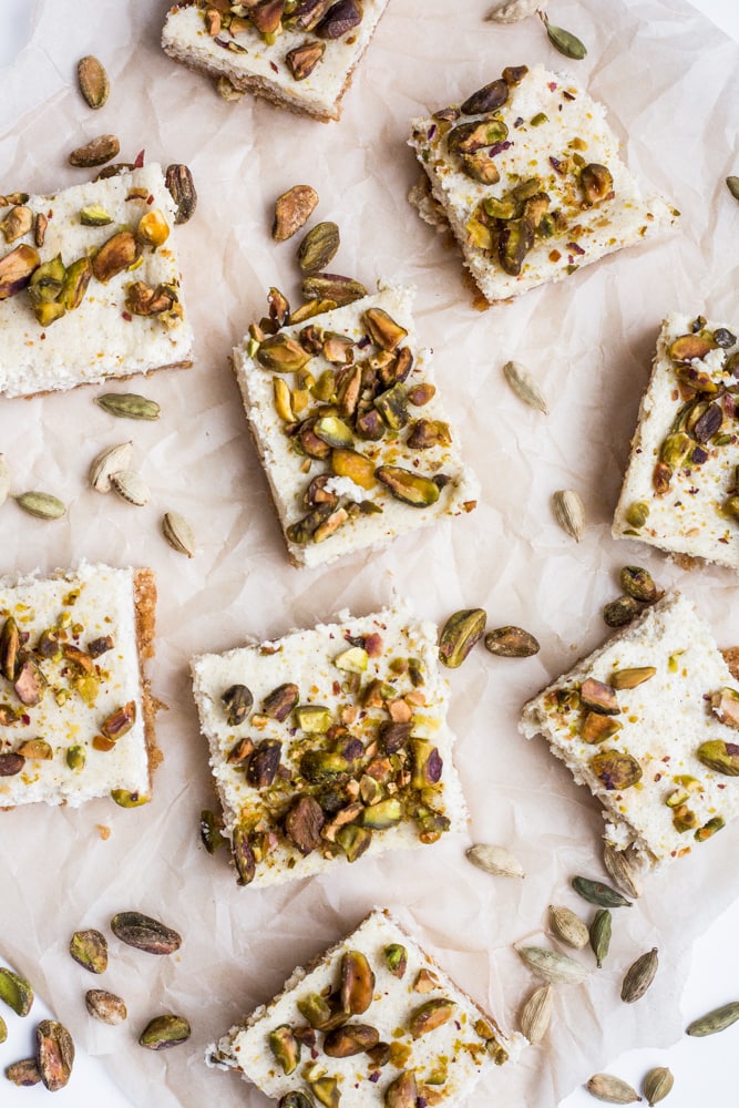 Cardamom and pistachio cheesecake squares on parchment paper