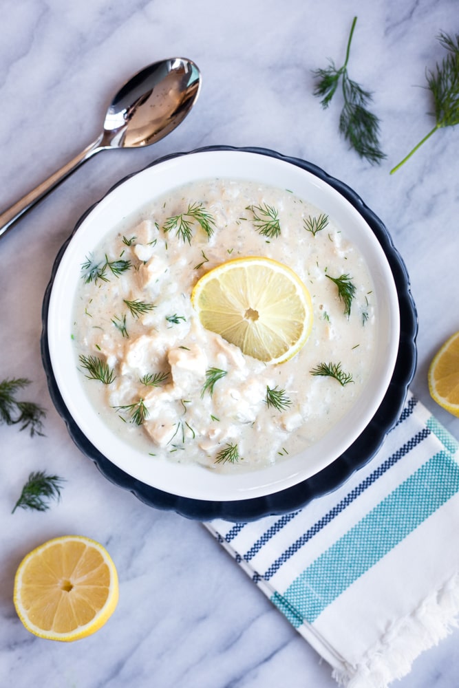 A bowl of Greek avgolemono soup topped with lemon and dill