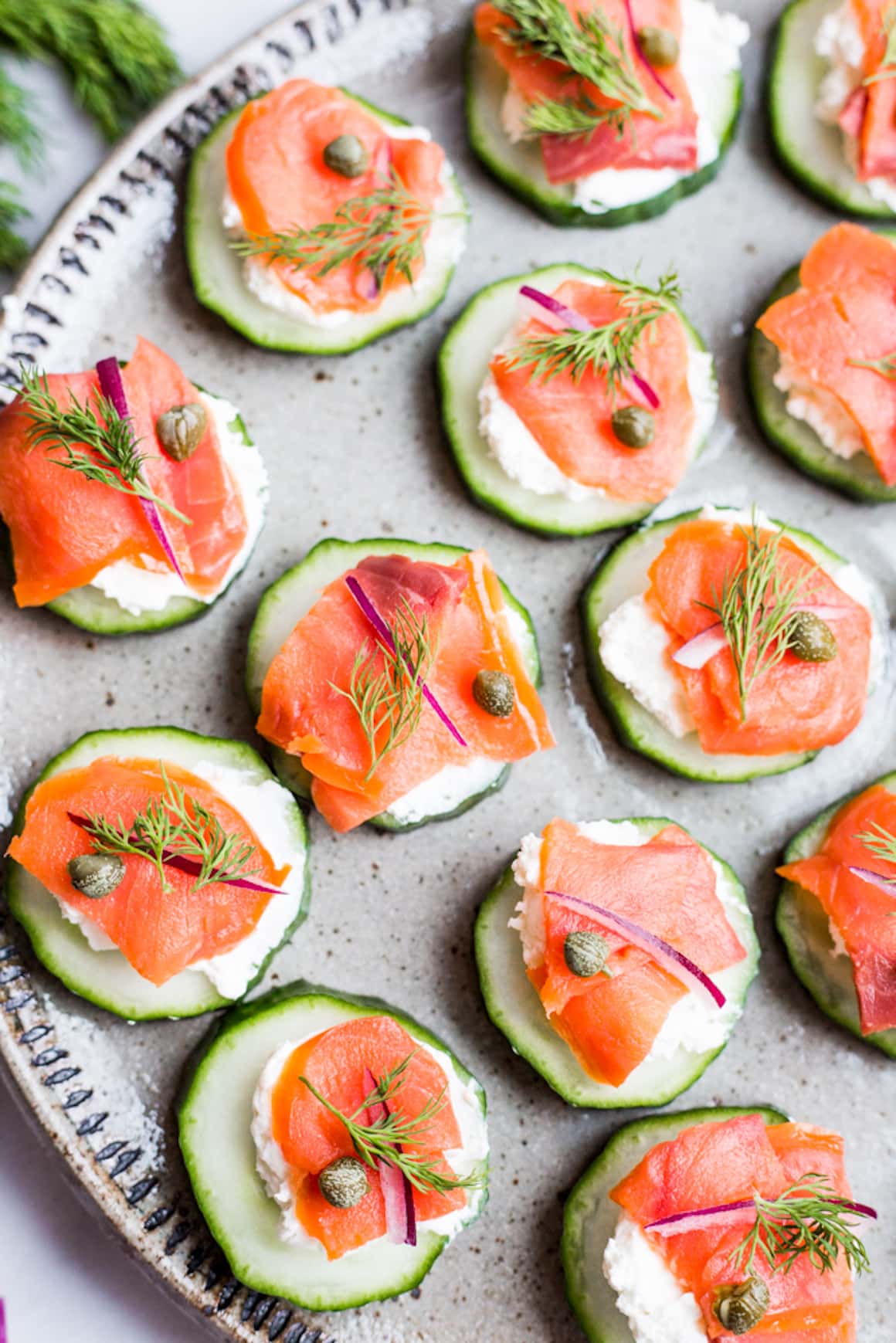 A plate of Cucumber canapés topped with cream cheese and smoked salmon