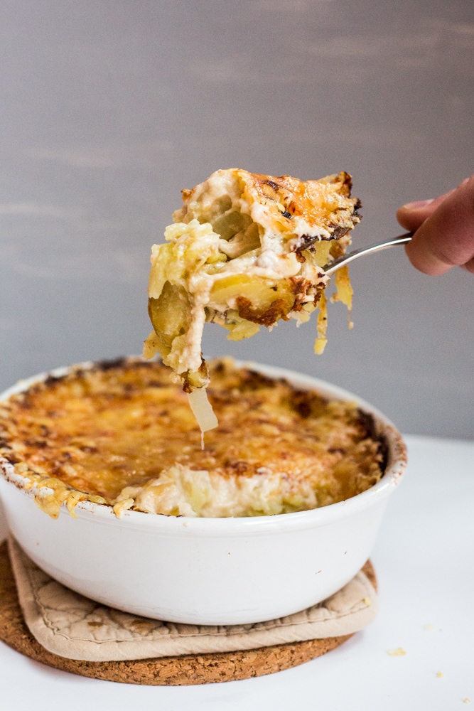 A pan of au gratin potatoes with a spoon
