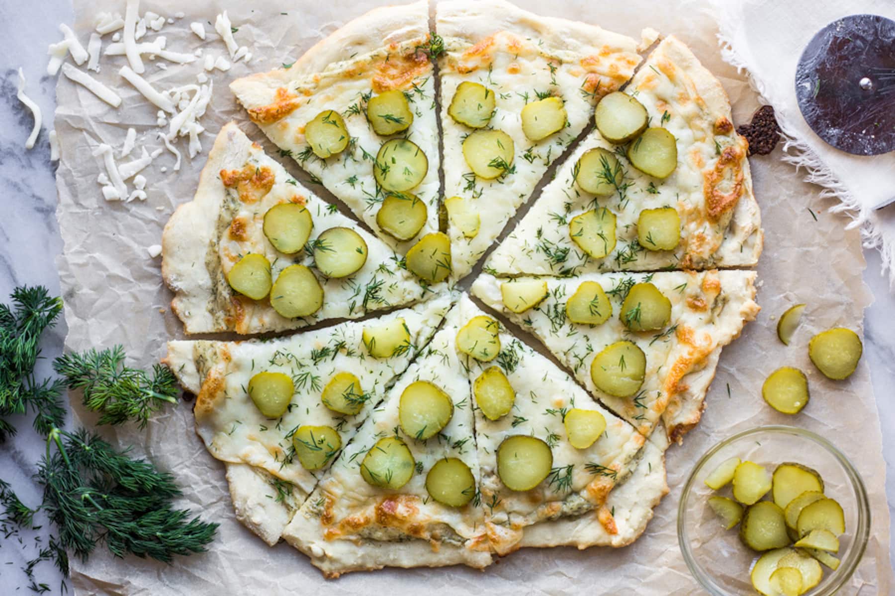 A sliced pizza topped with sliced pickles