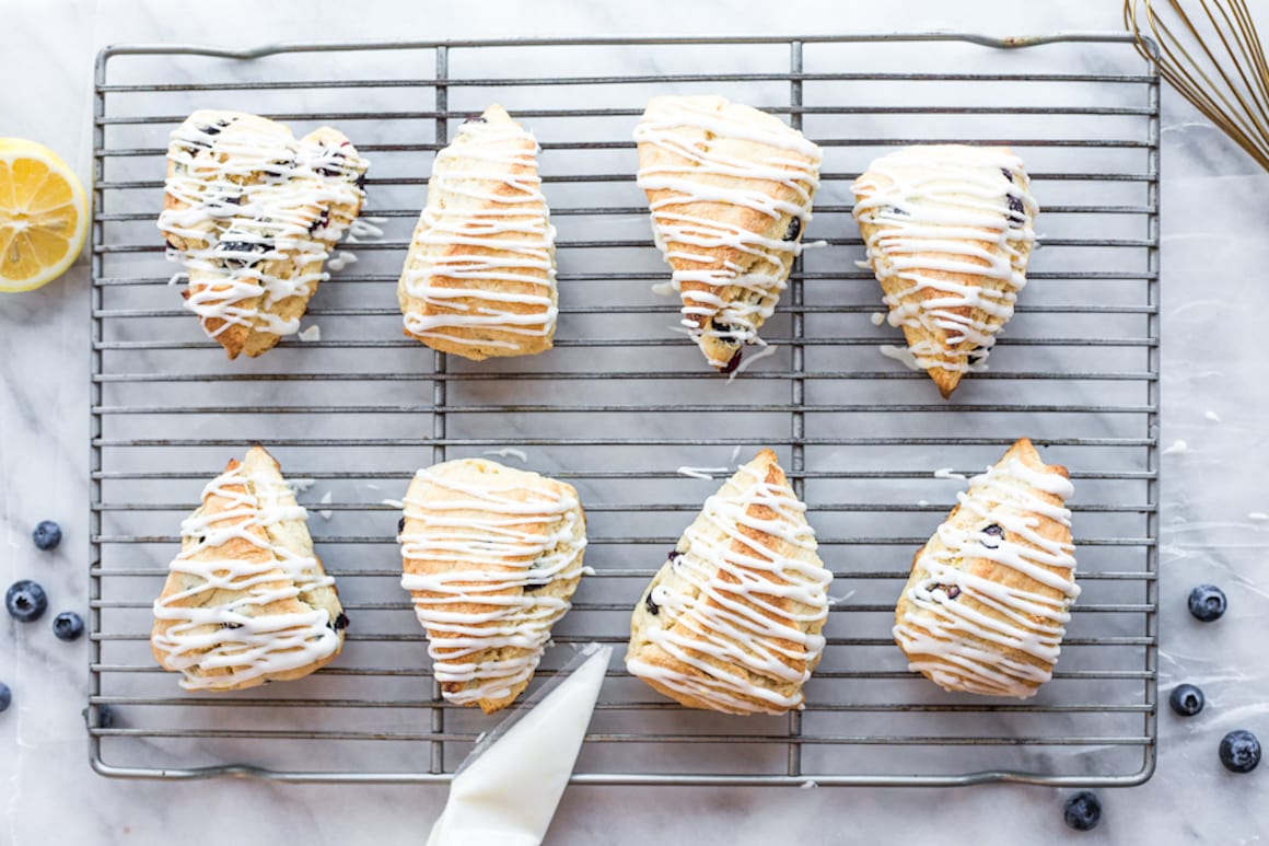 A cooling rack topped with scones that have been drizzled with icing