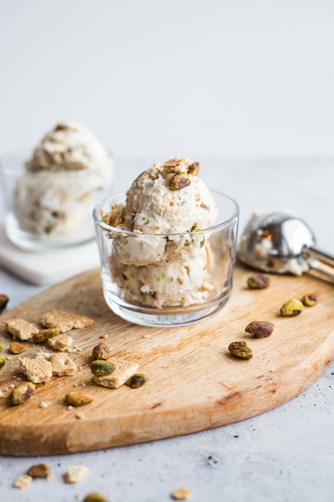 a dish of ice cream topped with and surrounded with crushed pistachios and graham crackers