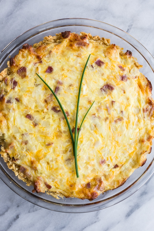 A bacon and Swiss quiche quiche topped with three chives