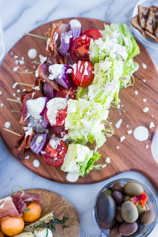 A platter of wedge salad skewers drizzled with blue cheese dressing