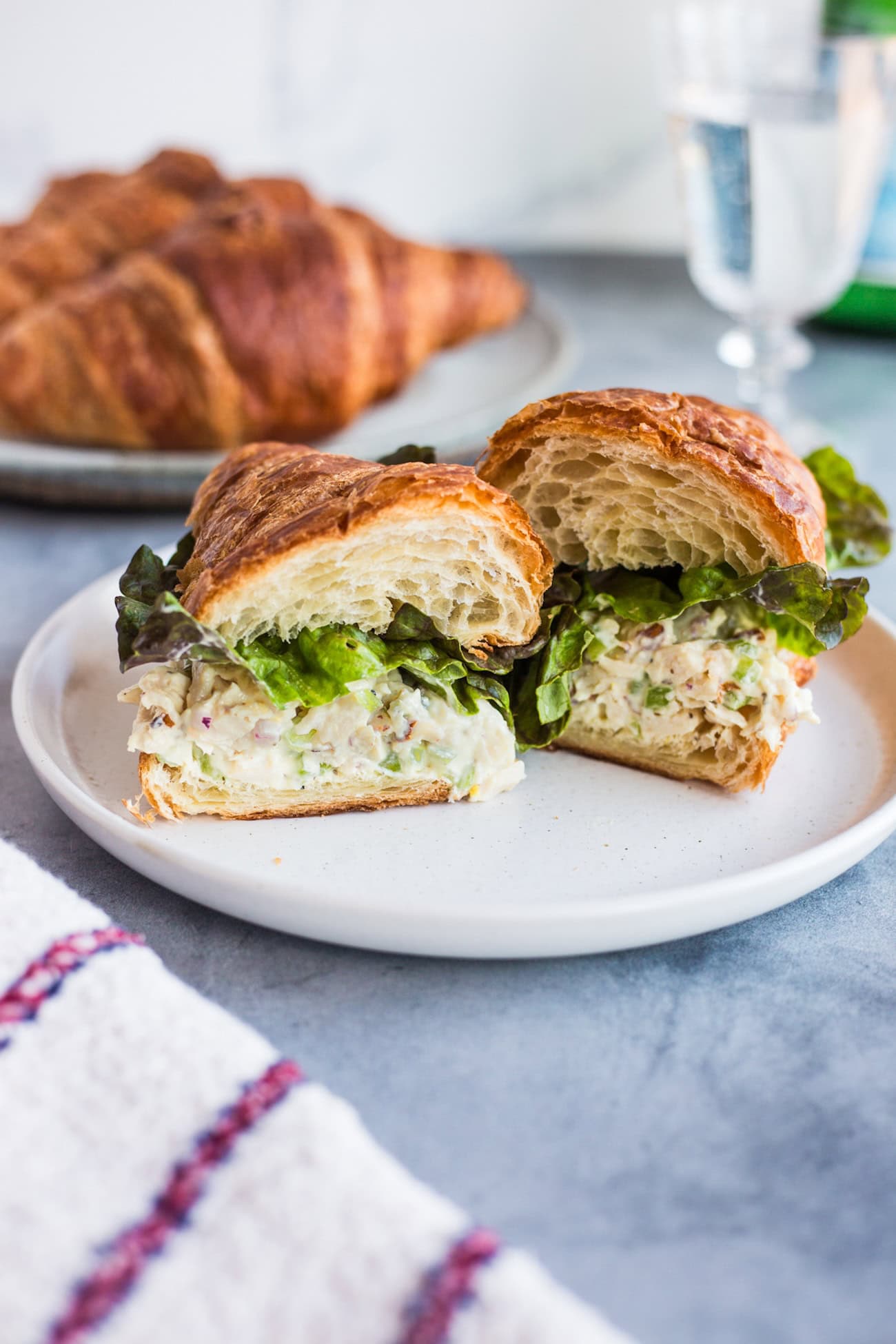 A croissant sandwich topped with chicken salad and lettuce