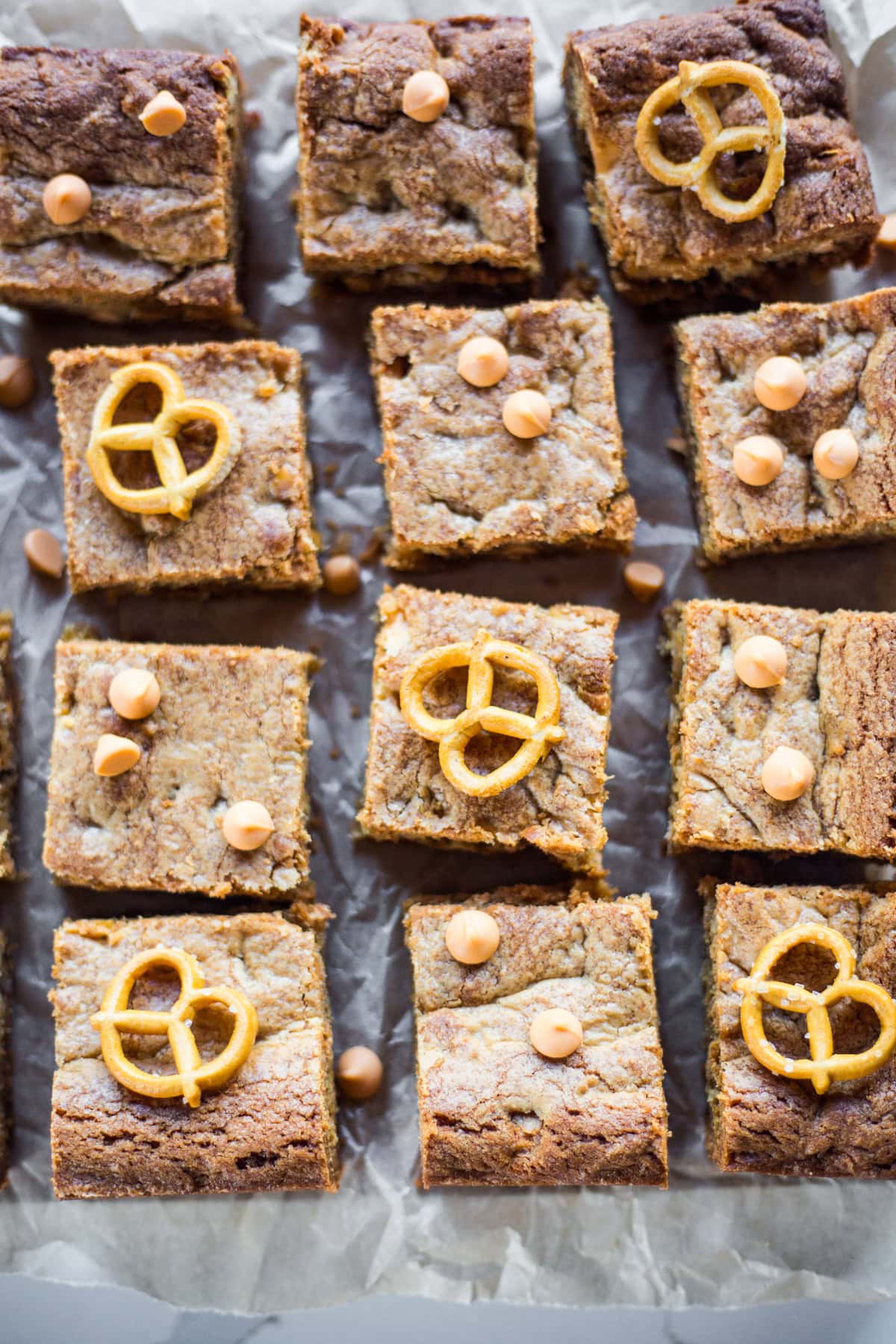 Square cut Blondies topped with pretzels and peanut butter chips