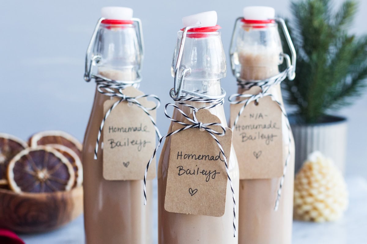 Three glass bottles with tags that say "Homemade Baileys"