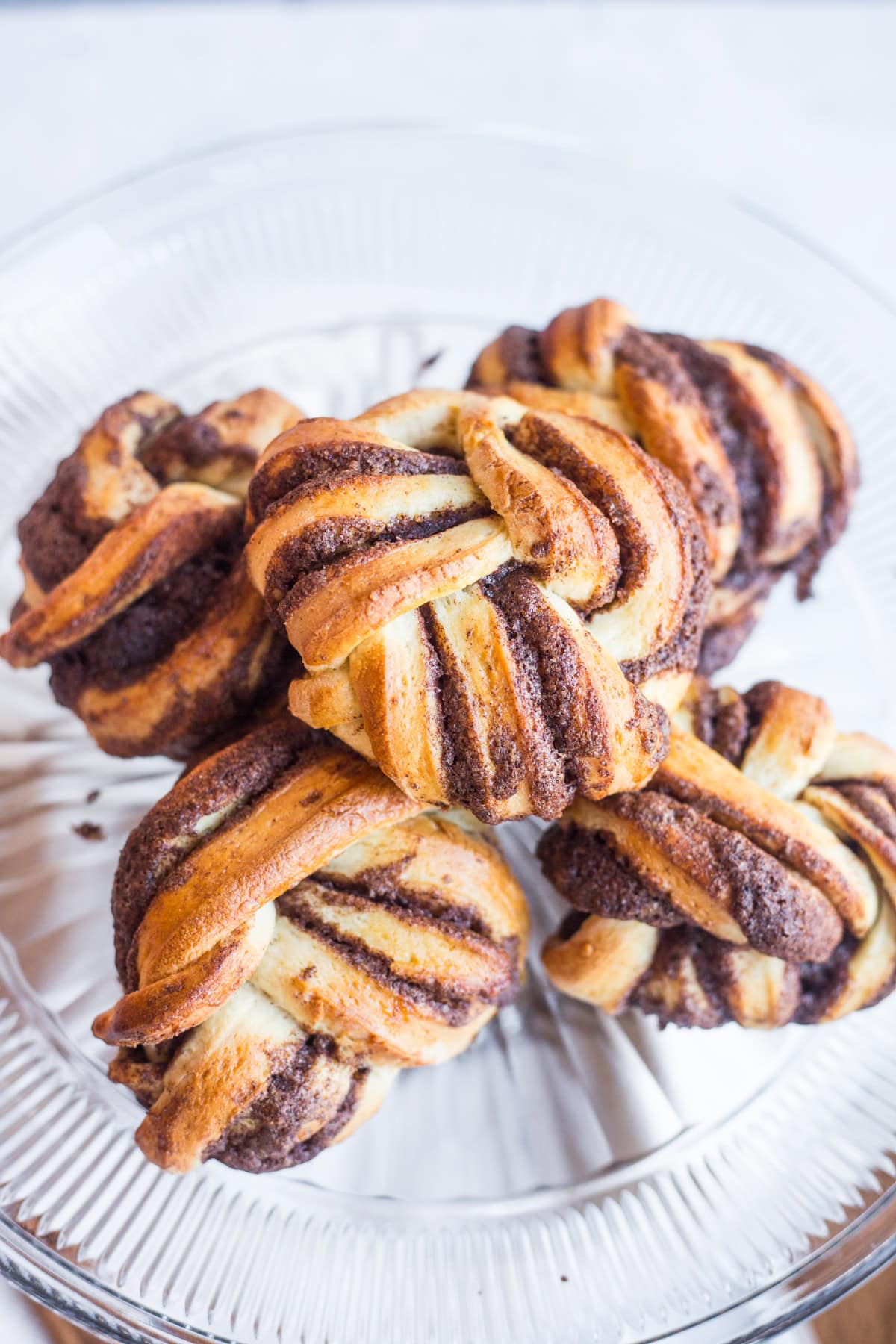 A glass platted topped with braided cinnamon buns