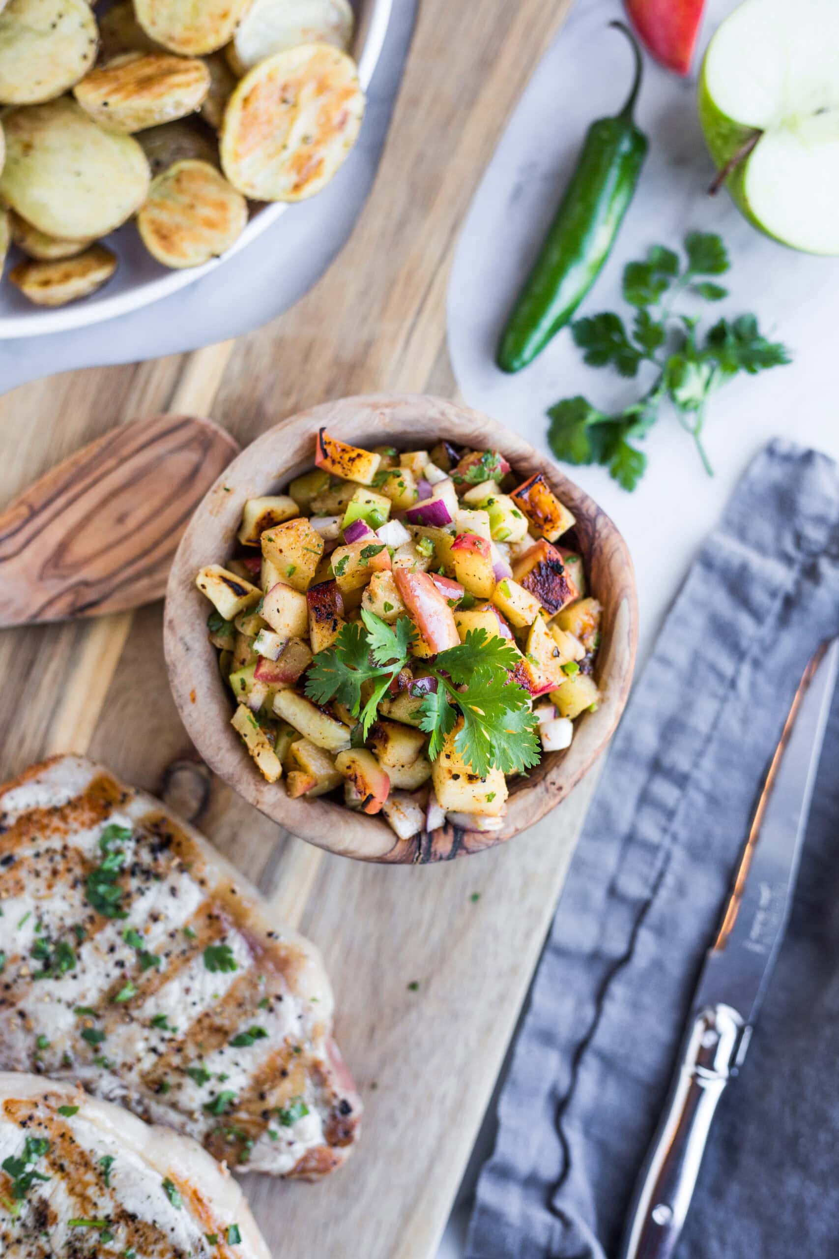 A wooden bowl filled with grilled apple salsa